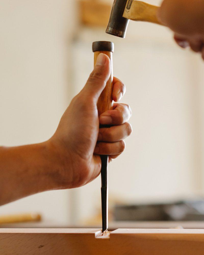 Hands working a wood chisel by hand